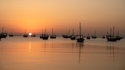 Arab traditional dhows in the shore during the sunrise in Qatar