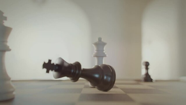 The game of chess. Checkmate, game over. King falls. Close-up macro shot of chess pieces on the chessboard. Photorealistic studio shot 3d animation.