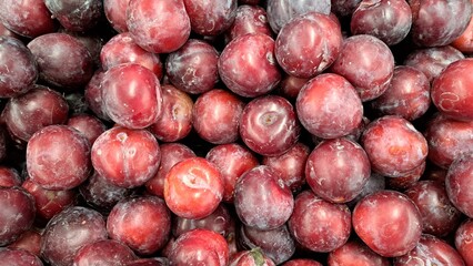 Red plums. Located throughout the frame. Top view. Background. Texture. Copy space