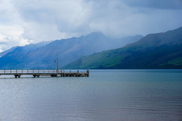 Wooden dock in mountain lake on a cloudy day