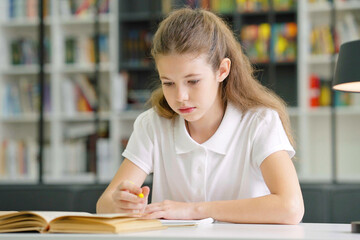 Intelligent school girl writing in class