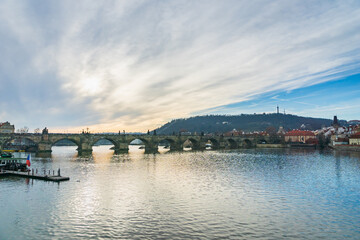 Fototapeta na wymiar Prague cityscape - winter view of Vltava river, tourist boat, Charles Bridge, old town in Prague, Czech Republic. Taken in the city center of Prague.