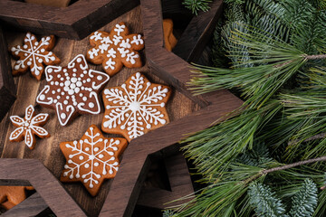 Wooden star and christmas cookies in box background with fir branches