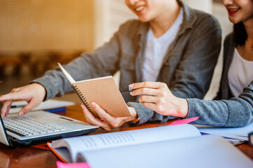 Two students are sitting at table reading books to education. Study for test preparation in University.Education, Learning, Student, Campus, University, Lifestyle concept.