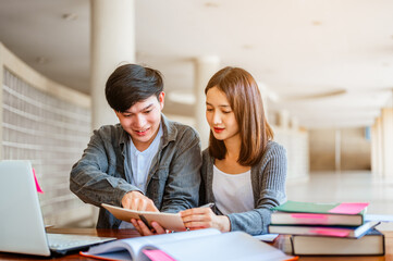 Two students are sitting at table reading books to education. Study for test preparation in University.Education, Learning, Student, Campus, University, Lifestyle concept.