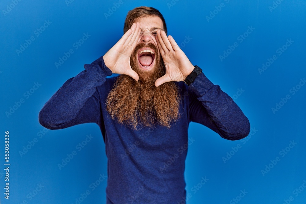 Canvas Prints redhead man with long beard wearing casual blue sweater over blue background smiling cheerful playin