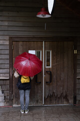 woman with umbrella in front of door