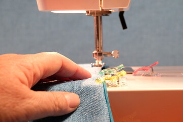 Hand mit einer Nähmaschine
