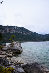 Eibsee Aussicht auf türkis blaues Wasser mit einer Insel mit den bayrischen schneebedeckten Alpen / Bergen im Hintergrund