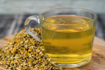 A cup of chamomile tea with dried chamomile flower, traditional medicine, remedies for cold