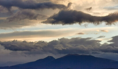 Nuvole nere e cielo azzurro sopra le montagne