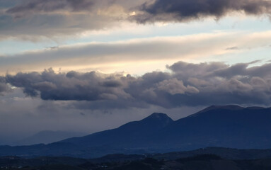 Fototapeta premium Nuvole nere e cielo azzurro sopra le montagne