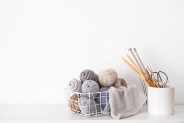 Handmade basket with neutral yarn for knitting and crochet. Knitting needles, hooks and scissors. Homey cozy atmosphere. copy space