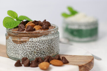 chia pudding with chocolate and almonds on white table