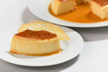 guomert pudding with yellow tulie garnish on white background
