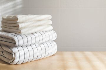 Obraz na płótnie Canvas Bath fresh towels pile soft textile cotton body care neatly folded white gray laundry flower shelf