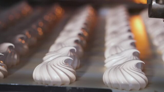 Conveyor belt movement with white marshmallows. Close-up. Confectionery factory.
