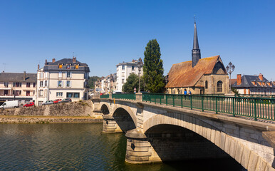 Scenic summer view of Sens townscape overlooking arched bridge across Yonne river and medieval catholic church of Saint-Maurice on embankment on sunny day, France © JackF