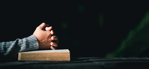 Prayer person hand in black background. Christian catholic woman are praying to god in dark at...