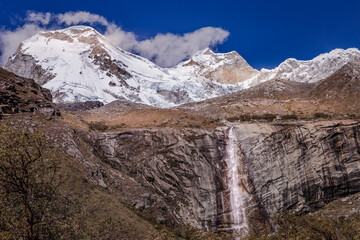 Waterfall and Huascaran massif in Cordillera Blanca, snowcapped Andes, Ancash, Peru