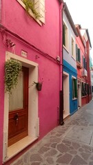 Small bright colorful old houses on the island of Burano, Italy. Local flavor and traditions on the Venetian island of Burano