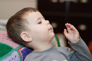 Expressive boy watching cartoons in the livingroom