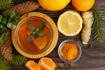 Flat lay composition with glass cup of delicious immunity boosting tea and ingredients on wooden table