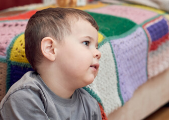 Expressive boy watching cartoons in the livingroom