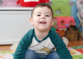 expressive young boy posing for portraits in his room surrounded by toys © Klarion