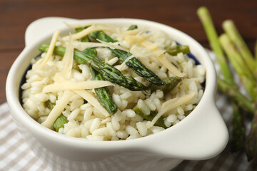 Delicious risotto with asparagus served on table, closeup