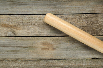 Baseball bat on wooden table, top view with space for text. Sports equipment