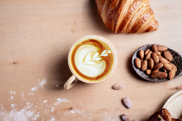 Hot coffee and croissants on vintage wooden background. Breakfast with coffee and fresh pastries.