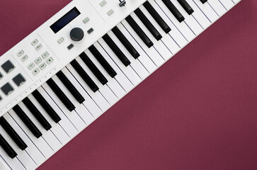 Fototapeta premium Midi keyboard on magenta background, flat lay, musical creativity concept, copy space.
