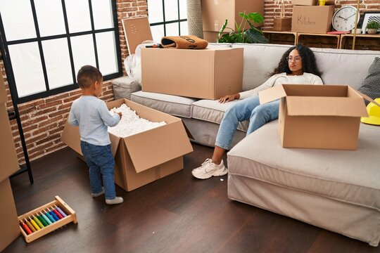 Mother And Son Tired Sitting On Sofa At New Home