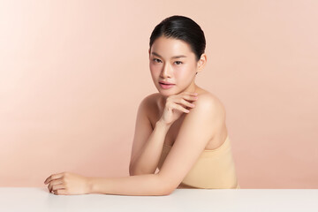 Naklejka premium Beautiful young asian woman with clean fresh skin on beige background, Face care, Facial treatment, Cosmetology, beauty and spa, Asian women portrait.
