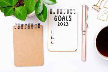 The inscription goals 2023 on notepad on white background, top view.