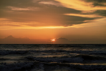 Naklejka na ściany i meble View of the golden sunset near the sea.
