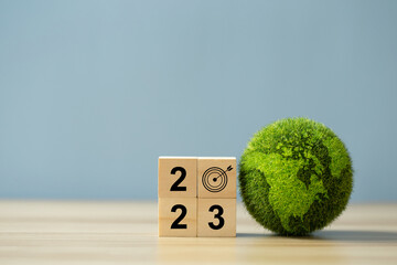 Goal in the new year 2023.Green business, Wooden cubes with numbers 2023 and green earth. Business...
