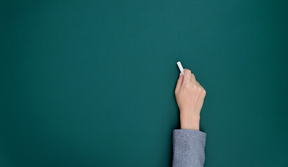 Businesswoman hand writing chalk on blackboard