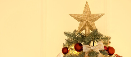 Decorated Christmas tree on beige background, closeup