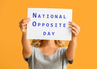 Woman holding paper sheet with text NATIONAL OPPOSITE DAY on orange background