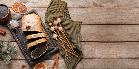 Board with tasty poppy seed strudel on wooden background with space for text