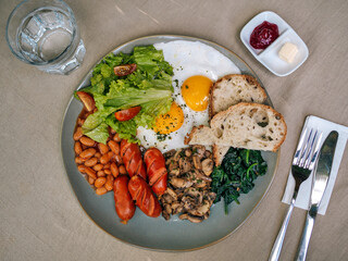 Big American breakfast with two eggs, mushroom, bean, sausages.