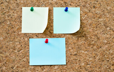 Three notes papers pinned on cork board