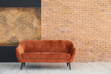 Red sofa near wall with old world map in room