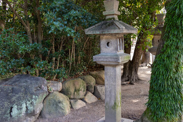 神社の境内に立つ古い石灯籠