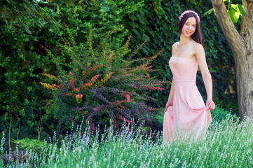Young woman in a pink dress in nature - 553097930