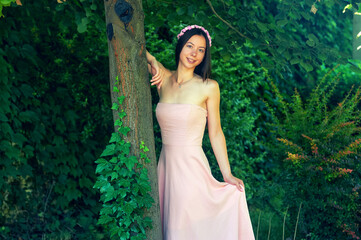 Young woman in a pink dress in nature - 553097931