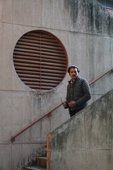 man wearing black glasses standing with wall
