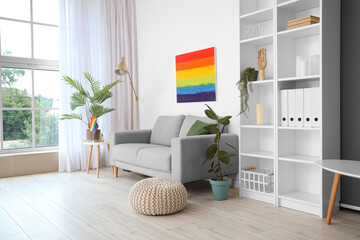 Interior of light living room with sofa, LGBT flag and painting